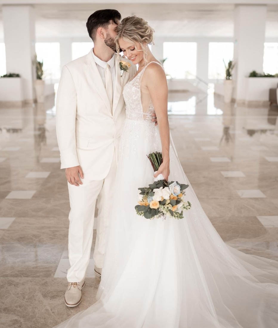 Сouple wearing a white gown and a white suit